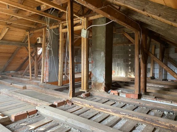 Dachgeschoss vor dem Rückbau – Holzständerwerk, alte Leitungen und marode Strukturen