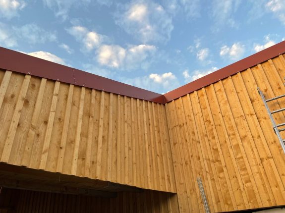 Massive Holzverkleidung mit Nut-Feder-System und Kantenschutz in Rotbraun