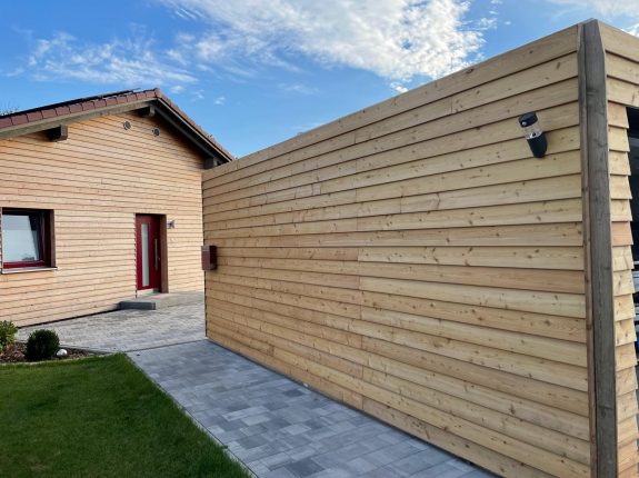 Hausfassade und Sichtschutzwand aus horizontaler Lärchenschalung