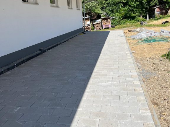 Carport-Auffahrt mit einheitlichem Rechteckpflaster in Grau
