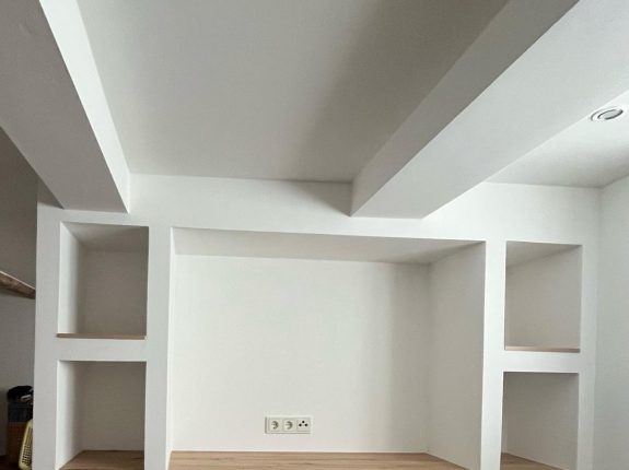 Individuell gefertigtes Trockenbau-Regalsystem in Weiß mit Holzflächen